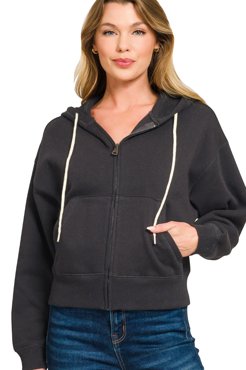 Woman wearing a black hoodie with white drawstrings on a white background