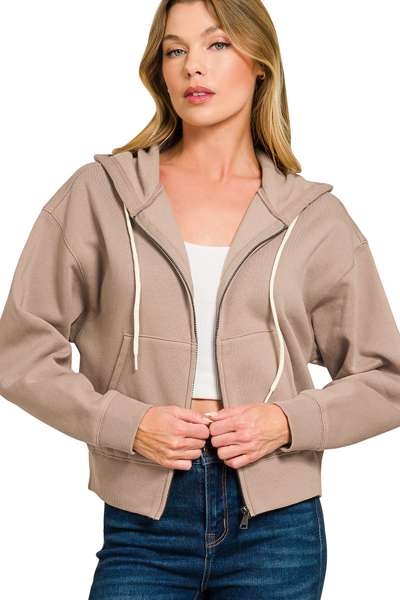 Woman wearing a beige hoodie with a white background