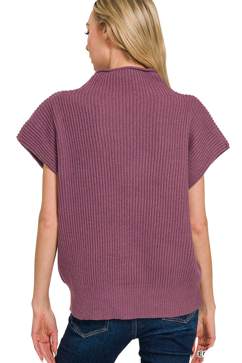 Woman wearing an eggplant-colored ribbed sweater on a white background