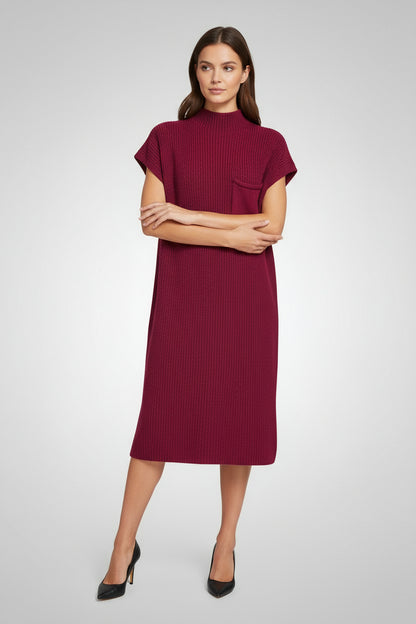 Woman wearing a cabernet-colored knit dress with a pocket on a white background